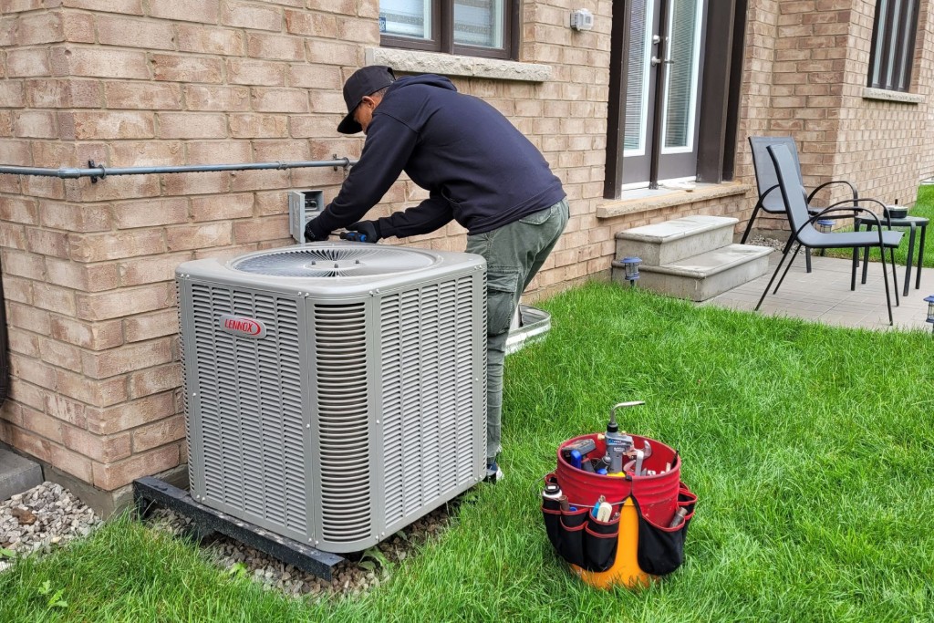 An LG Home Comfort technician repairs a heat pump.