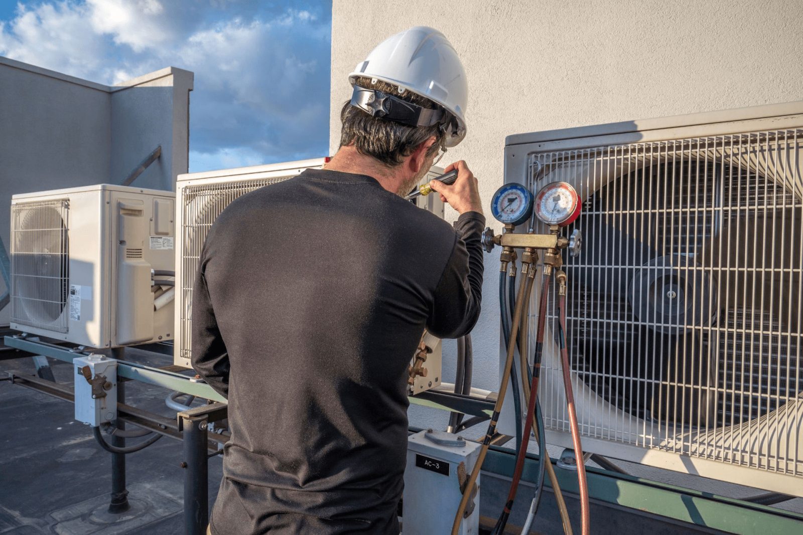 An HVAC technician inspecting an outdoor unit 