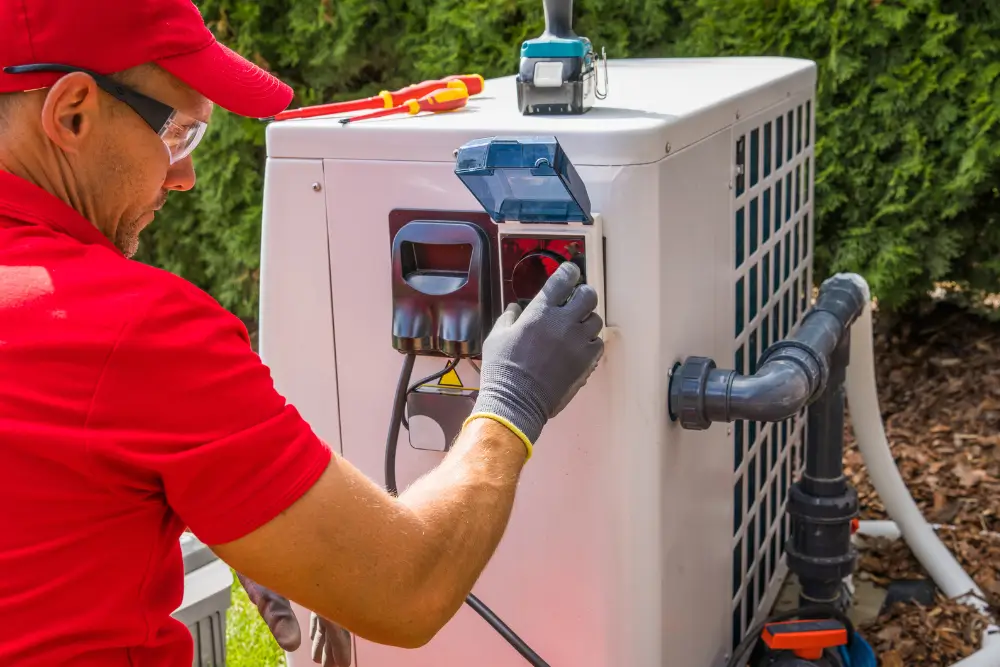HVAC specialist engaging exterior weatherproof power disconnect switch on aquatic thermal pump chassis featuring rigid PVC circulation manifold