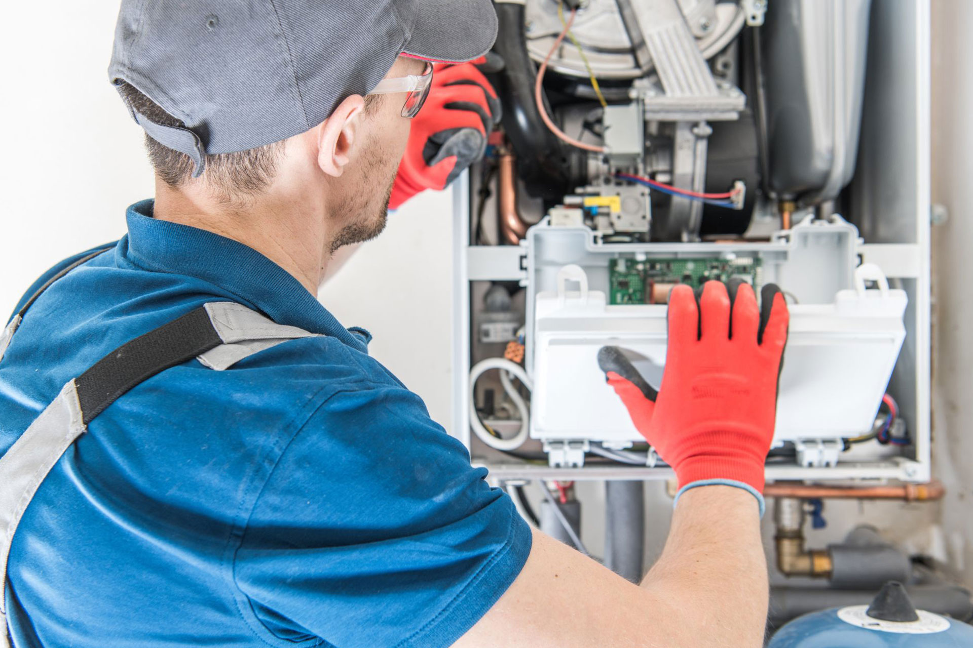 An HVAC technician inspecting an open furnace