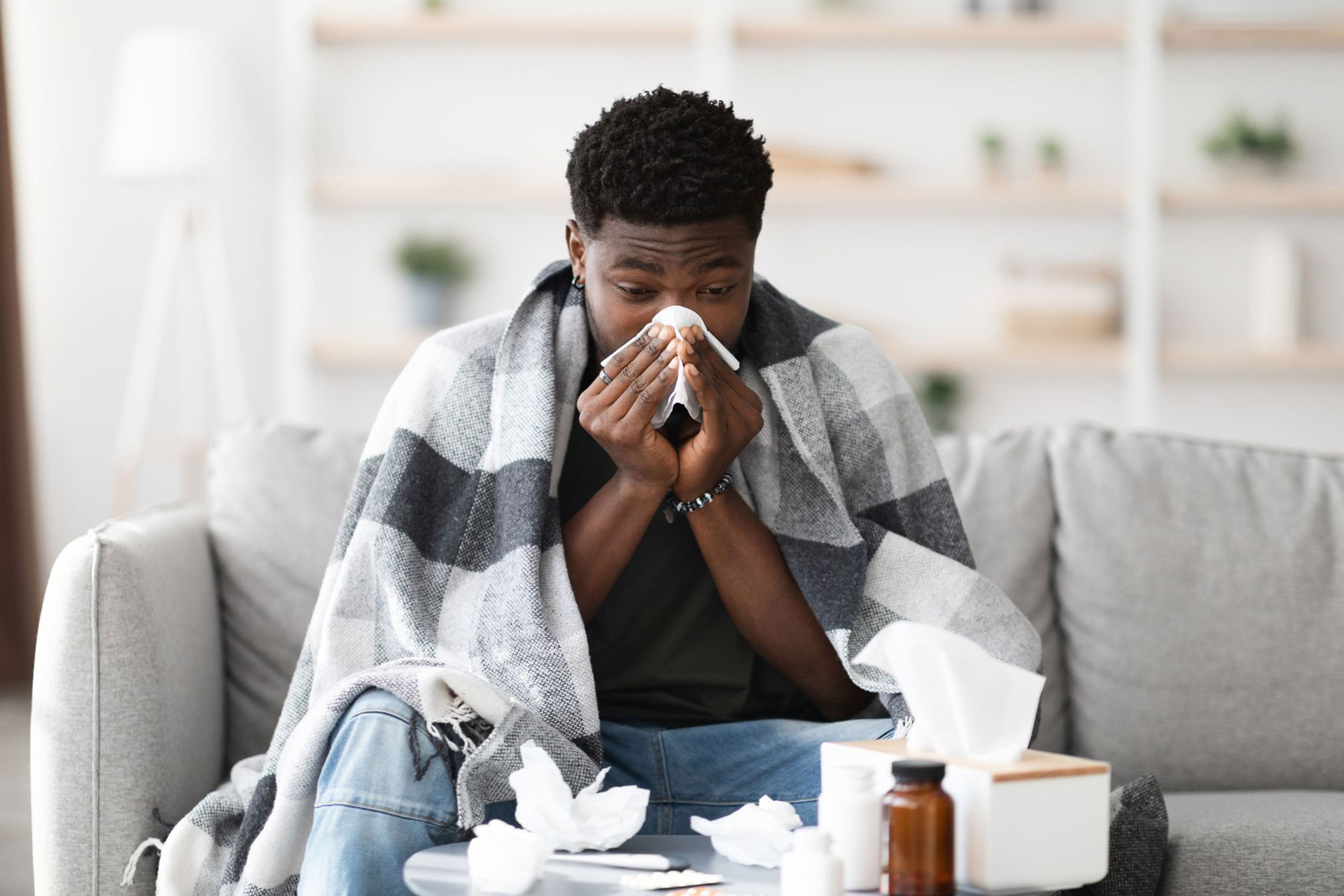 A man blowing his nose with a tissue