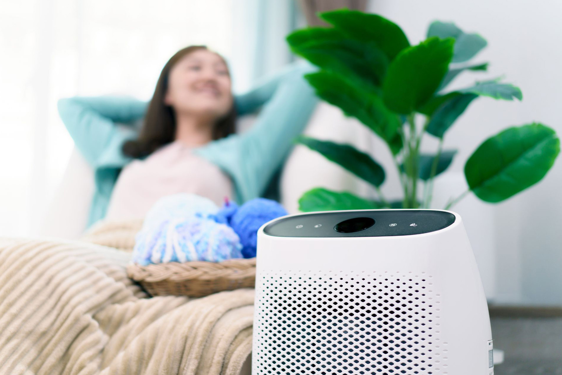 A woman relaxing in the living room with an air purifier