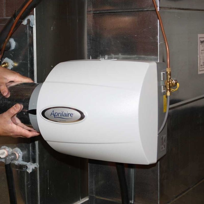 Technician setting up humidifier to boost air quality in Mount Forest, ON - LG Home Comfort