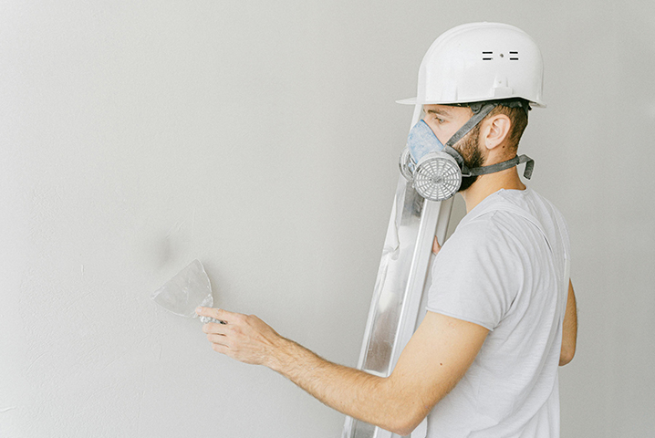 A technician waterproofing a wall to reduce humidity.