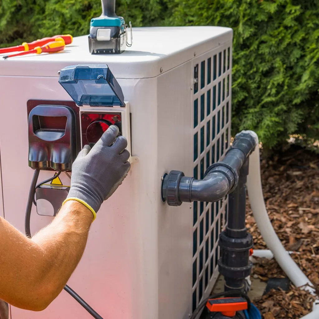 High-voltage electrical power isolation procedure on an outdoor exterior heat pump condenser unit prior to mechanical system diagnostics.
