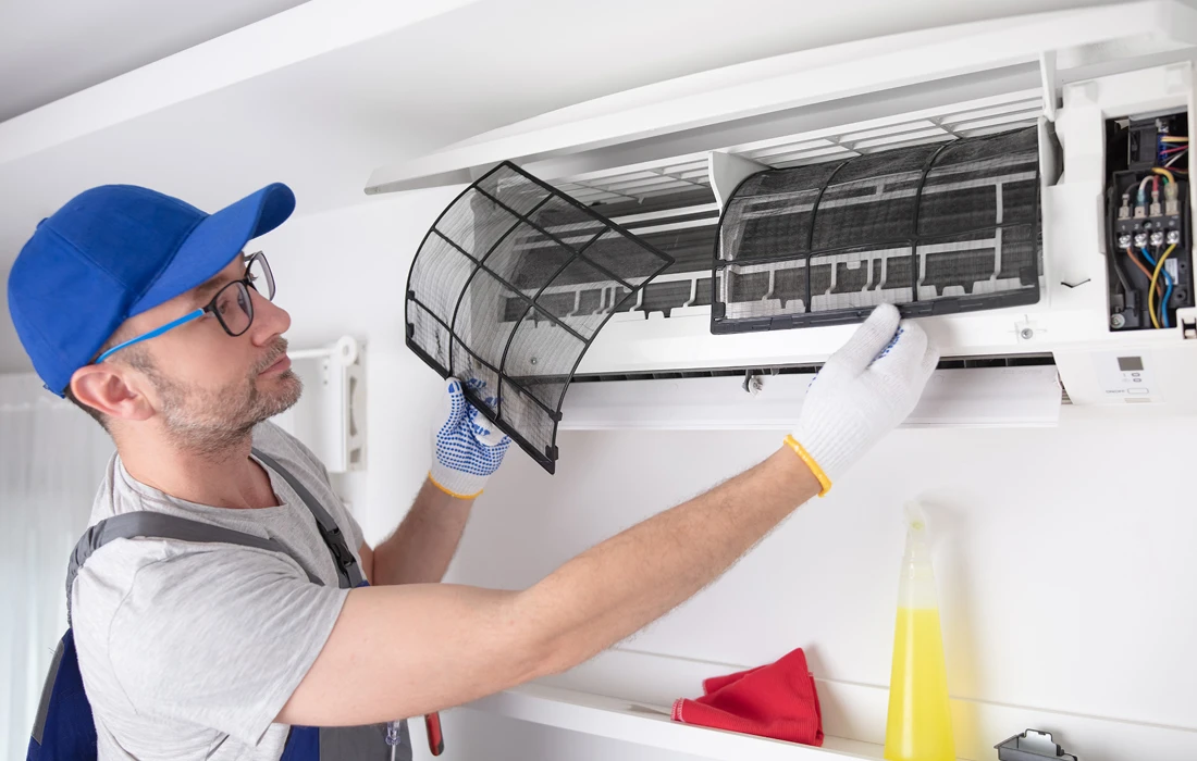 HVAC professional removing filters from an AC