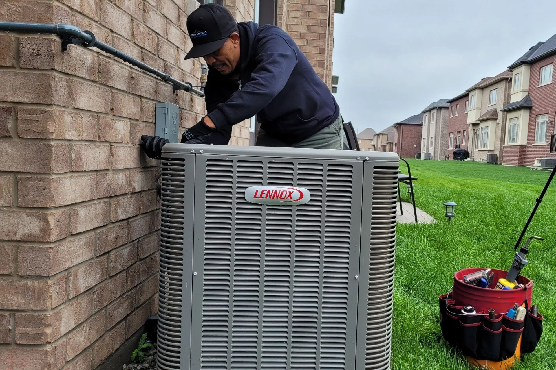 LG Home Comfort technician in a cap fixing outdoor unit