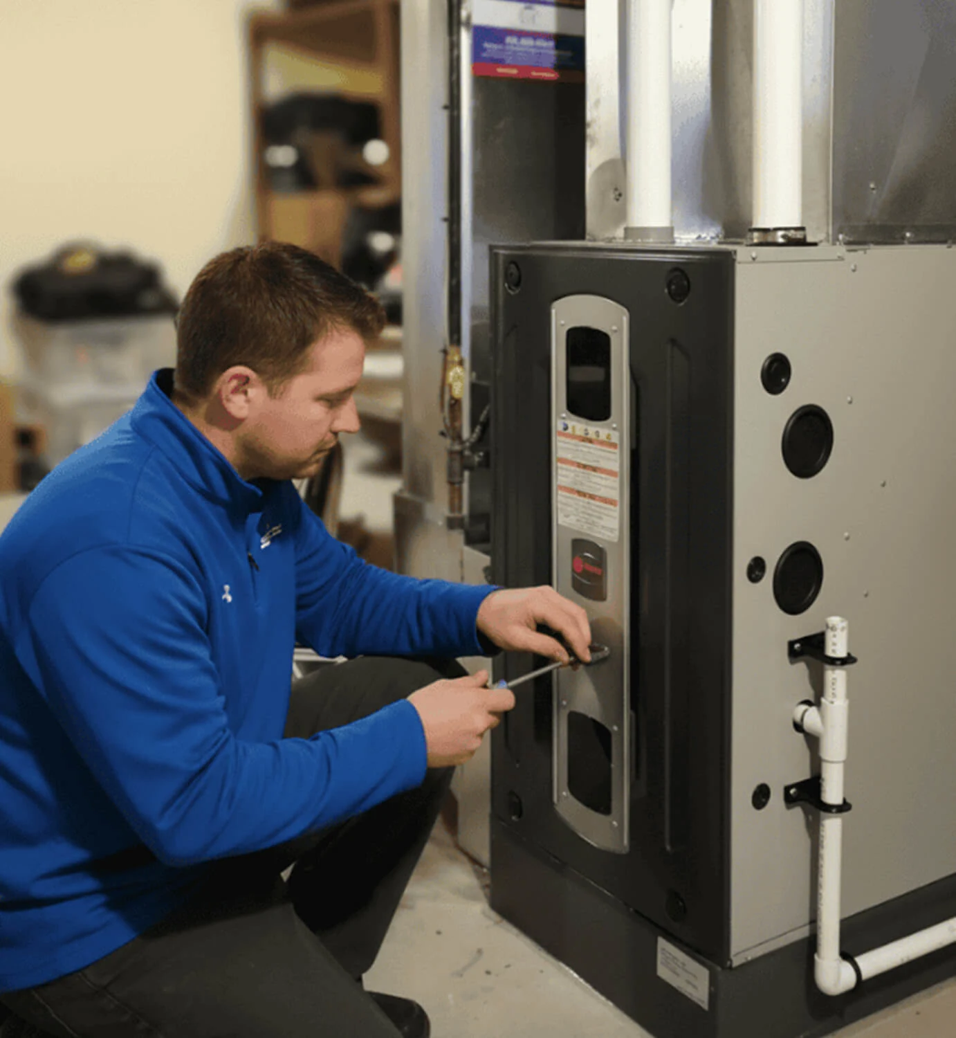 Professional HVAC technician performing expert residential furnace repair and maintenance on an indoor heating unit.
