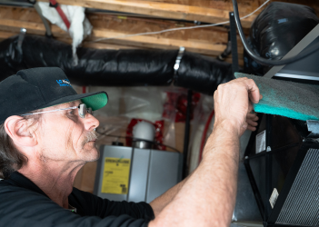 Technician installing an air purifier to enhance indoor air quality in a Hamilton residence - LG Home Comfort