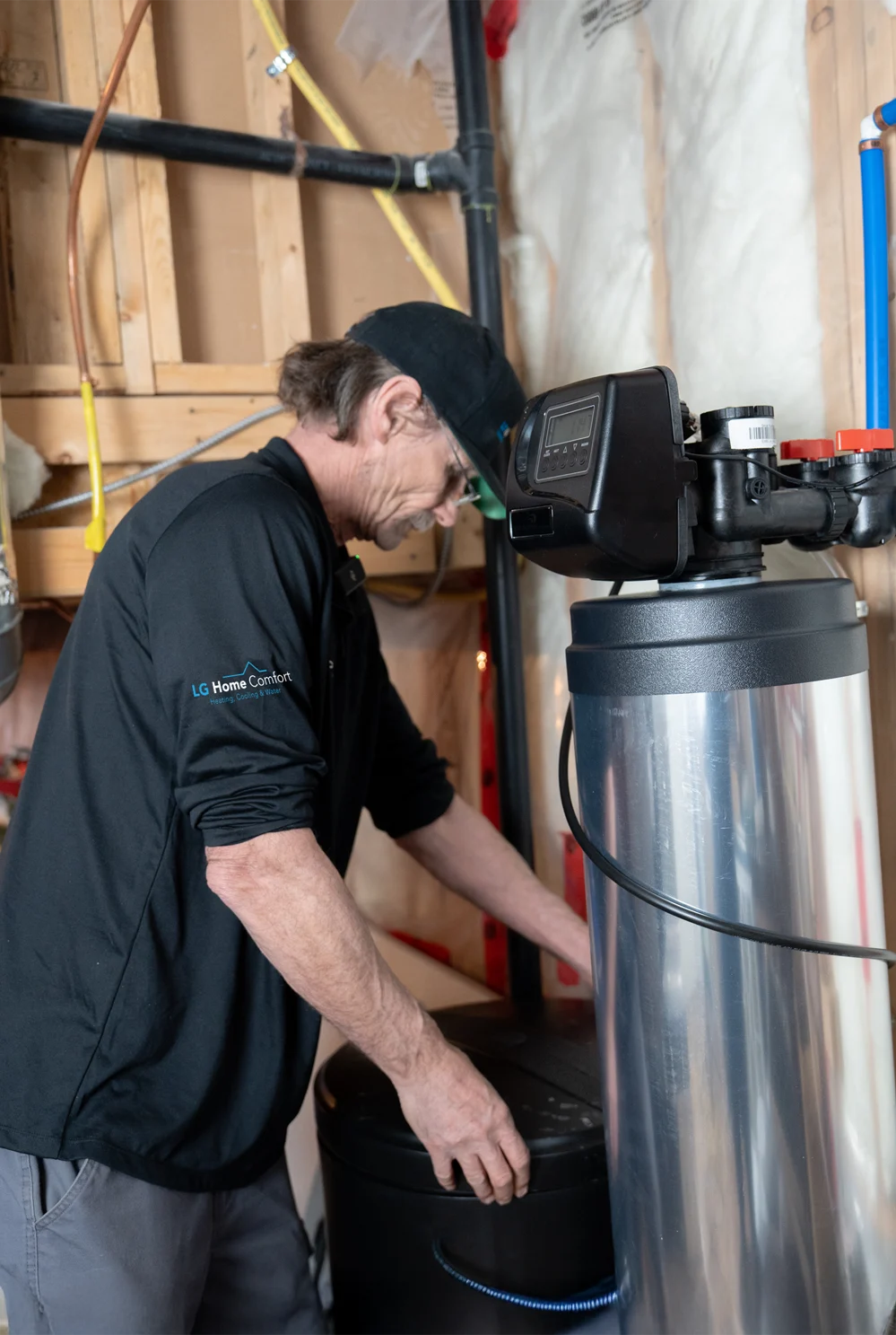 LG Home Comfort worker installing a whole-home water softener system.