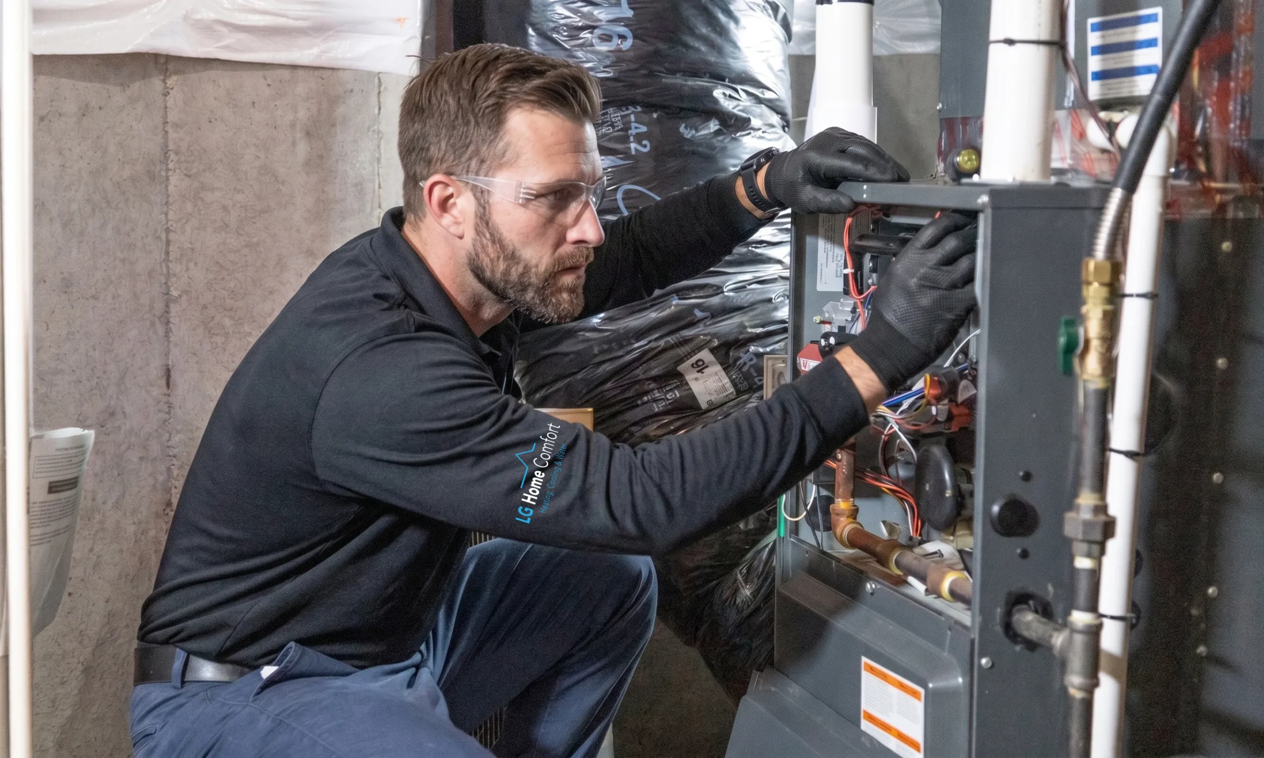 LG Home Comfort worker wiring a furnace's internal components.