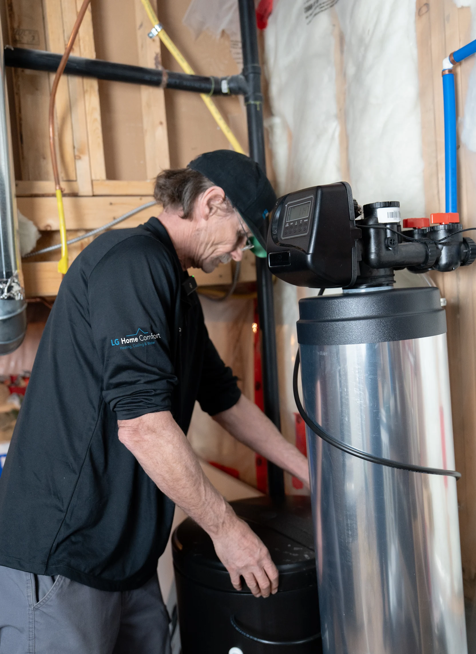 technician servicing a water softener system in a residential basement in Ajax in ontario