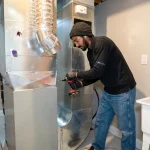 HVAC technician inspecting residential ductwork during spring HVAC maintenance in an Ontario home 